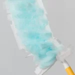 Duster de limpieza con cabezal azul y mango amarillo, ideal para eliminar el polvo de superficies delicadas.